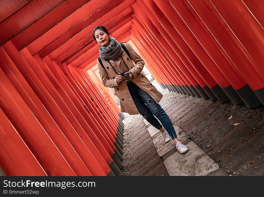 Full length photo of a confident female photographer walking in the Torii. Full length photo of a confident female photographer walking in the Torii