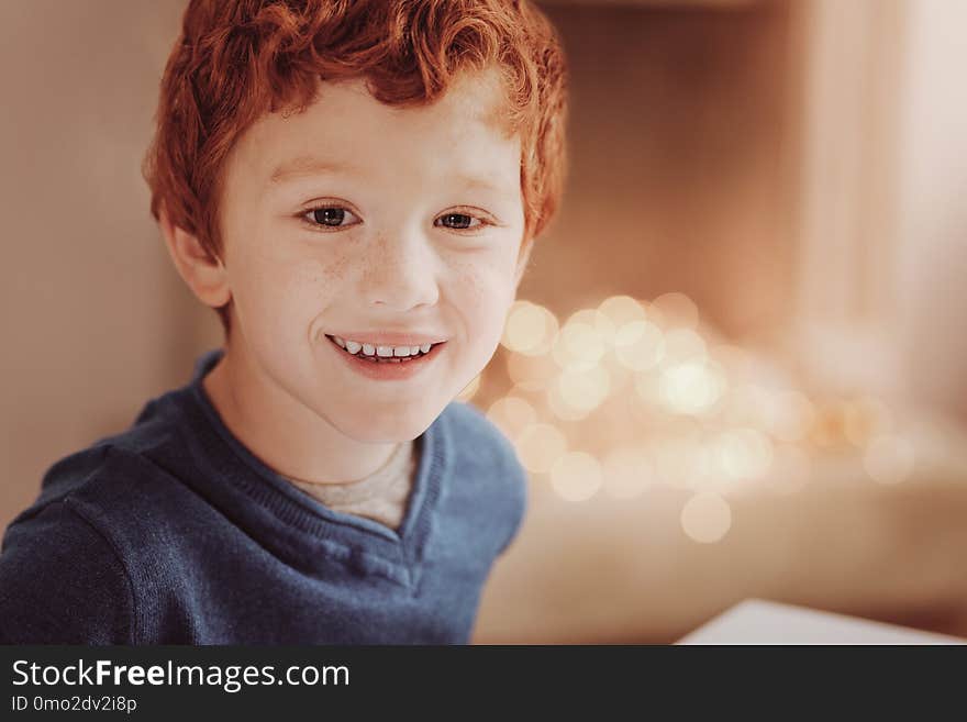 Pleasant emotions. Close up of little boy looking at you while expressing cheer on his face. Pleasant emotions. Close up of little boy looking at you while expressing cheer on his face