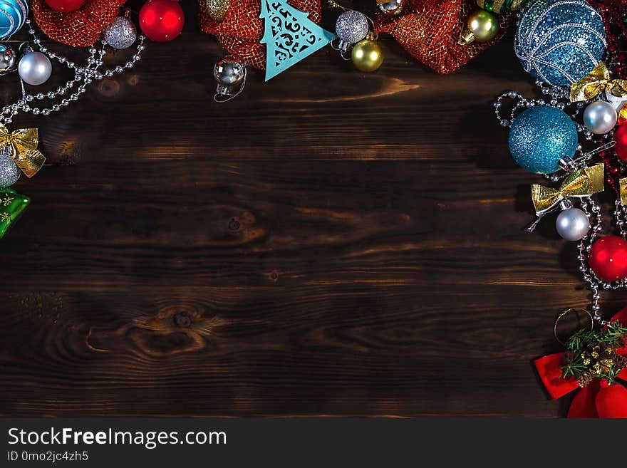 Christmas bright background a dark wooden table. Christmas decorations. Christmas toys. Christmas bright background a dark wooden table. Christmas decorations. Christmas toys.