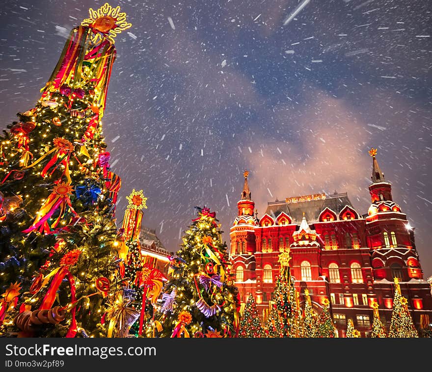 Decorated Christmas trees in honor of the Shrovetide week in Moscow near the Red Square. On the building written text Historical Museum. Beautiful Holiday scenery with holiday decorations christmas trees.