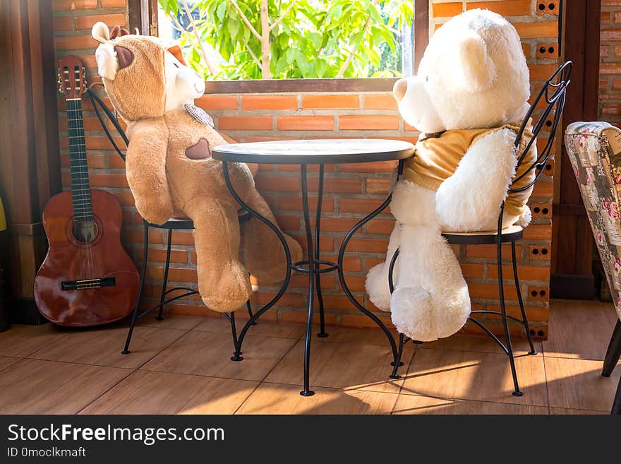 Two embracing teddy bear toys sitting on window-sill