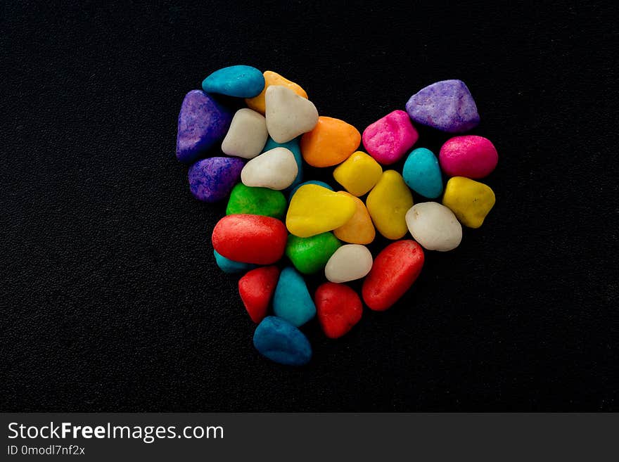 Colorful little pebbles form a heart shape