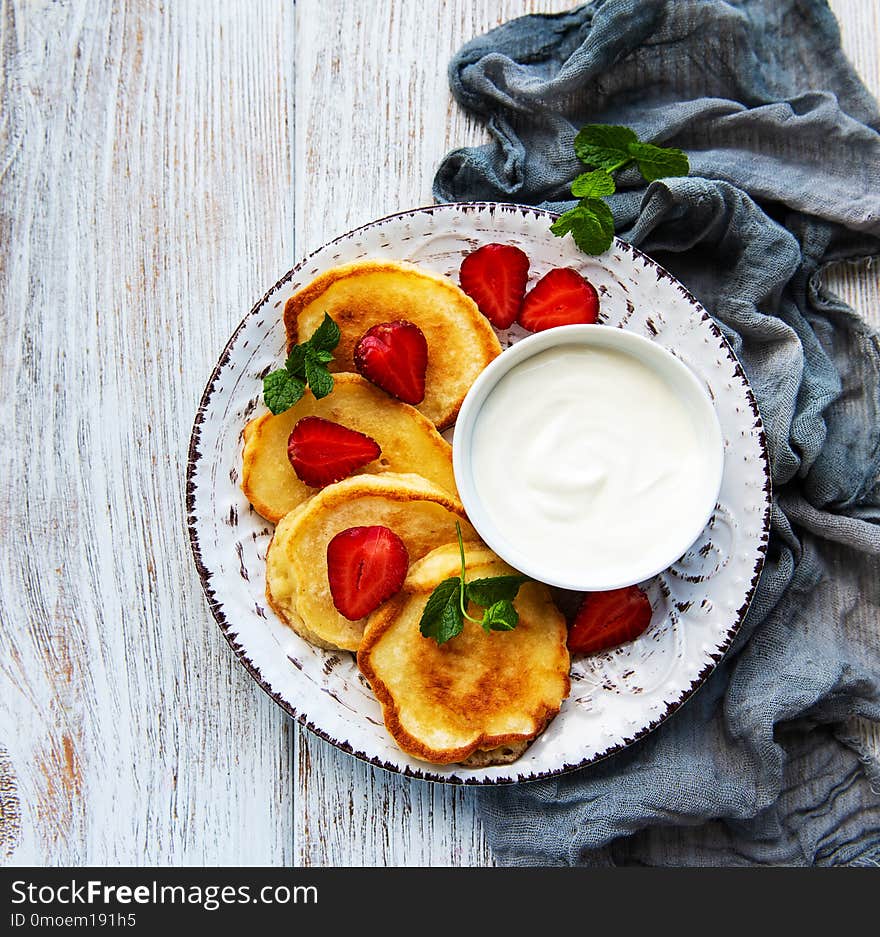 Delicious pancakes with strawberry on white wooden background