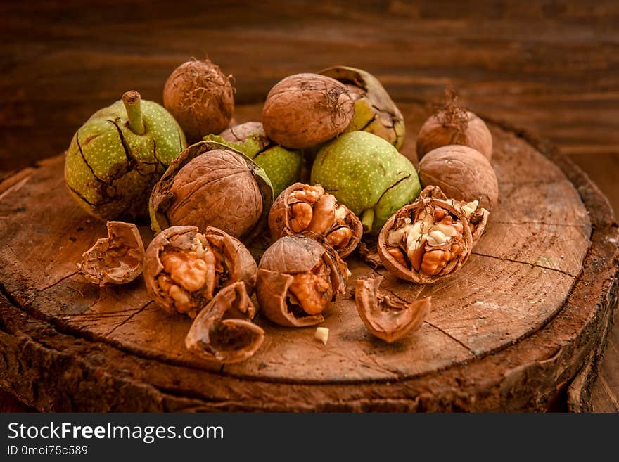 Walnuts with green leaves, on wooden background . Walnuts with green leaves, on wooden background .