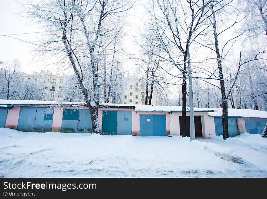 Winter morning. Chain of garages surrounded by snow piles