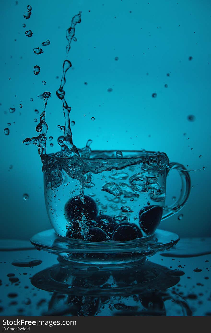 Splash of water in a cup on a blue background.