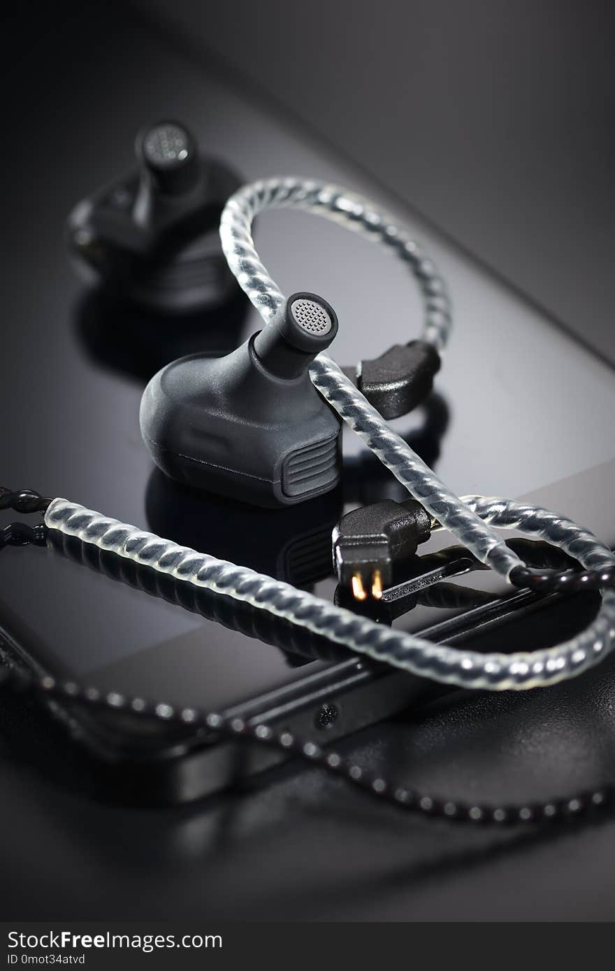 Black earbuds and smartphone