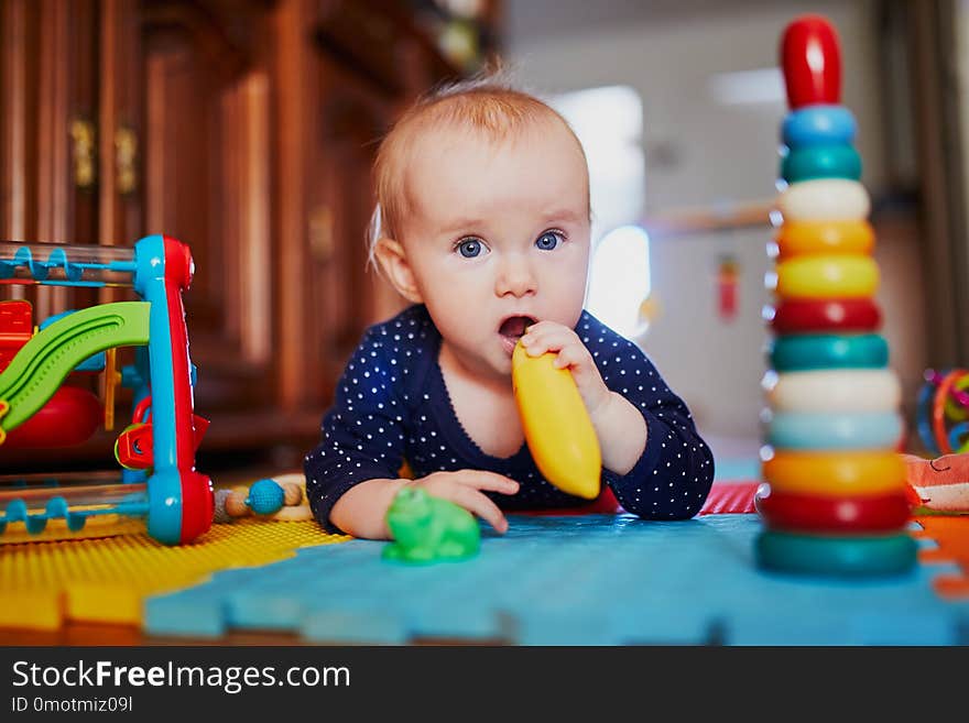 Baby girl playing with toys on the floor