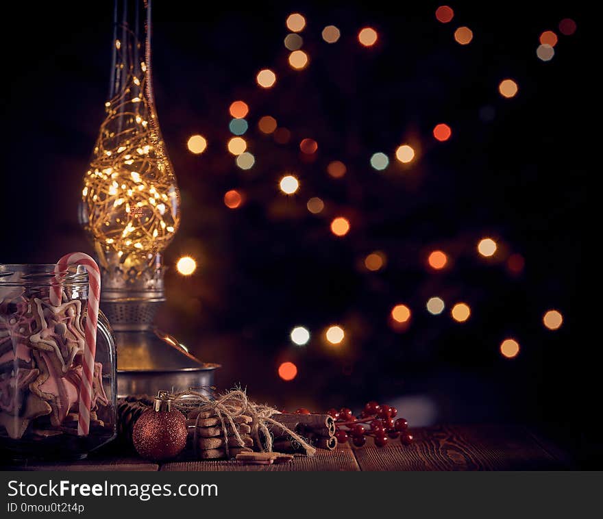 Christmas decor and gingerbread cookies lying on a wooden table on a dark background with light of garland. Copy space for text. Christmas and New Year. Christmas decor and gingerbread cookies lying on a wooden table on a dark background with light of garland. Copy space for text. Christmas and New Year.