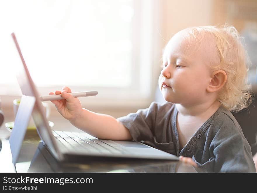 Little baby learning to use laptop computer .