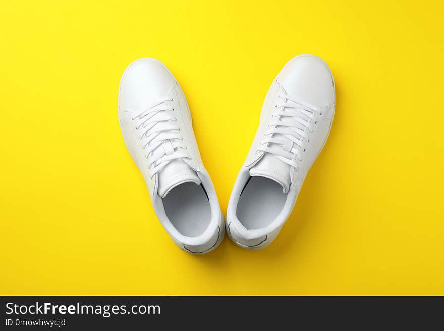 Pair of sneakers on color background