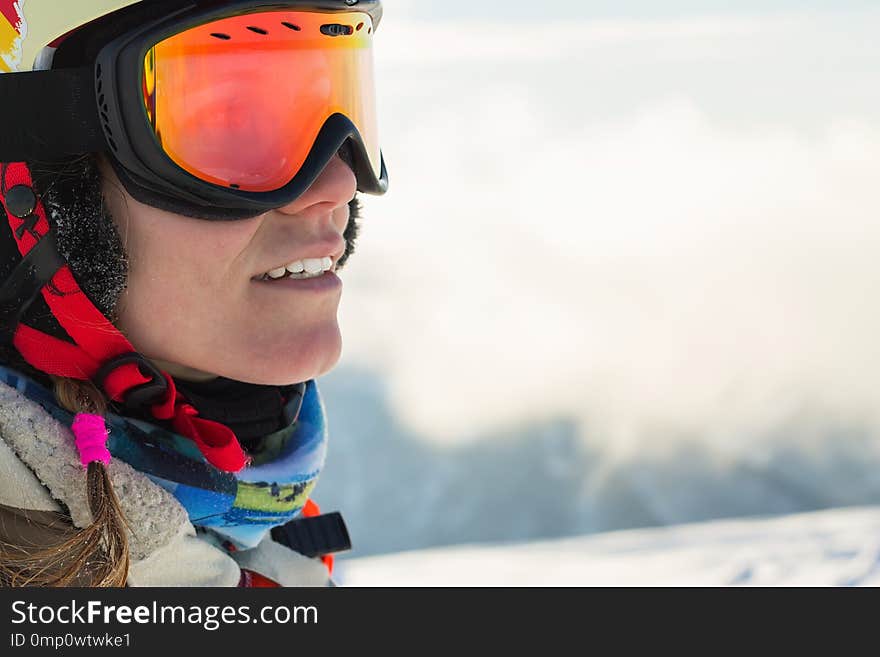 Portrait of a snowboarder woman freerider in helmet in snowy mountains.