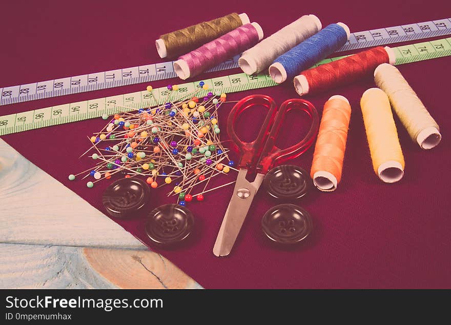 Supplies and accessories for sewing - scissors, threads, pins, buttons, centimeter.