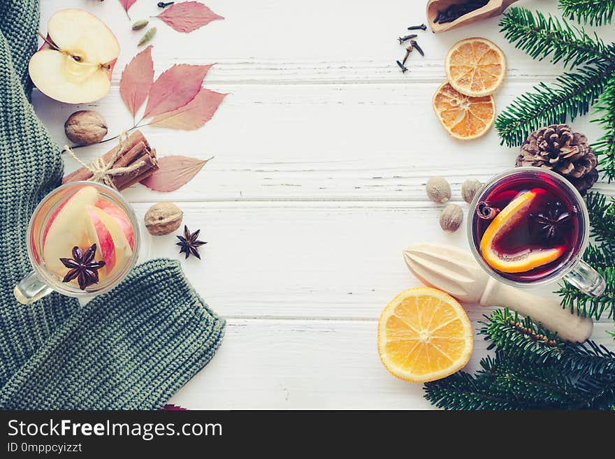 Autumn mulled wine with apple based on white wine ws Christmas mulled wine based on red wine with orange and Christmas spices on white wooden background. Seasonal and holidays. Top view. Copy space. Autumn mulled wine with apple based on white wine ws Christmas mulled wine based on red wine with orange and Christmas spices on white wooden background. Seasonal and holidays. Top view. Copy space.