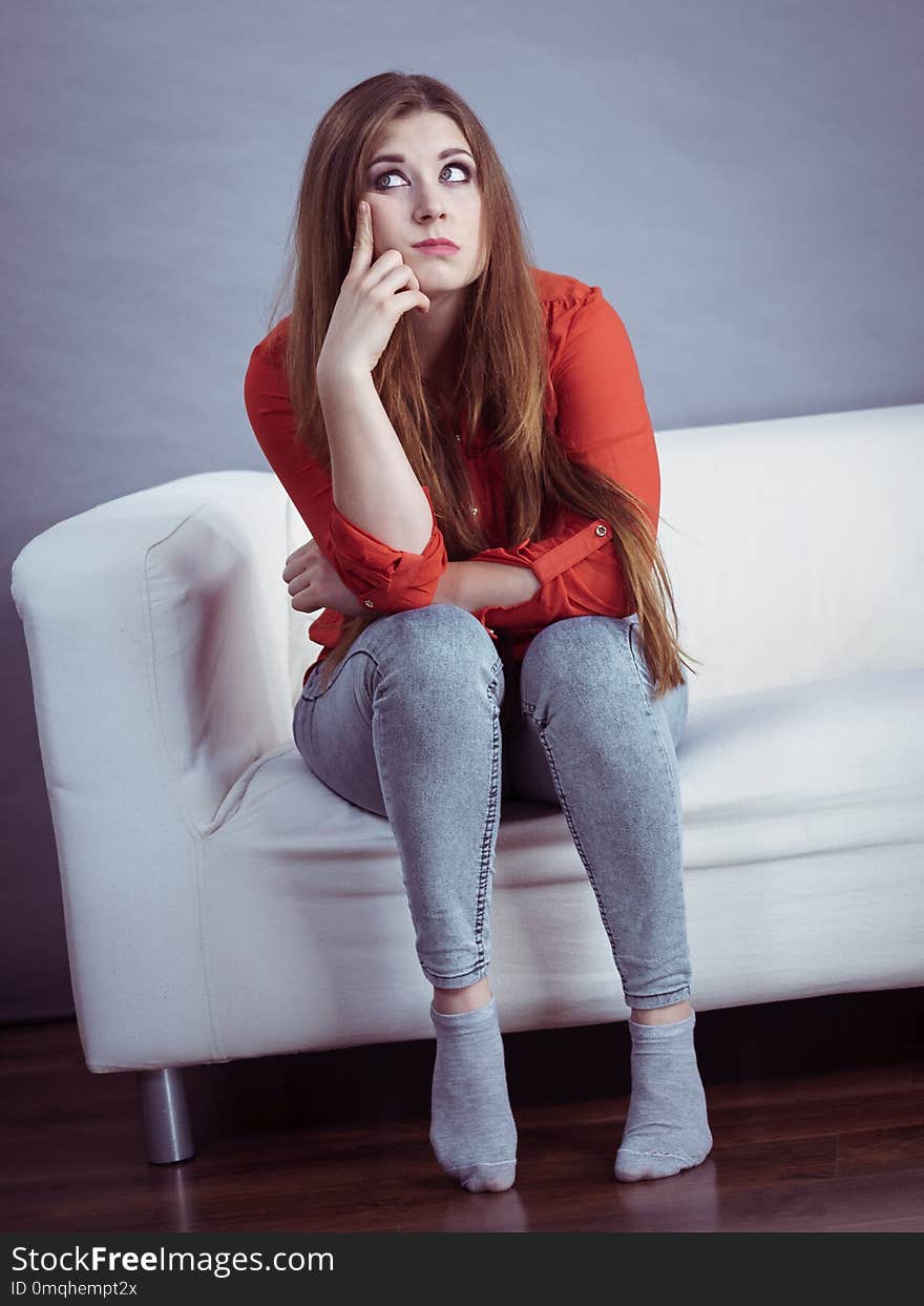 Angry, off young woman. Attractive female with long brown hair sitting on sofa being mad and irritated having displeased face expression. Angry, off young woman. Attractive female with long brown hair sitting on sofa being mad and irritated having displeased face expression.