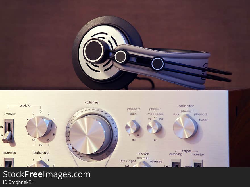 Audio Stereo Headphones on the top of Vintage Amplifier Front View