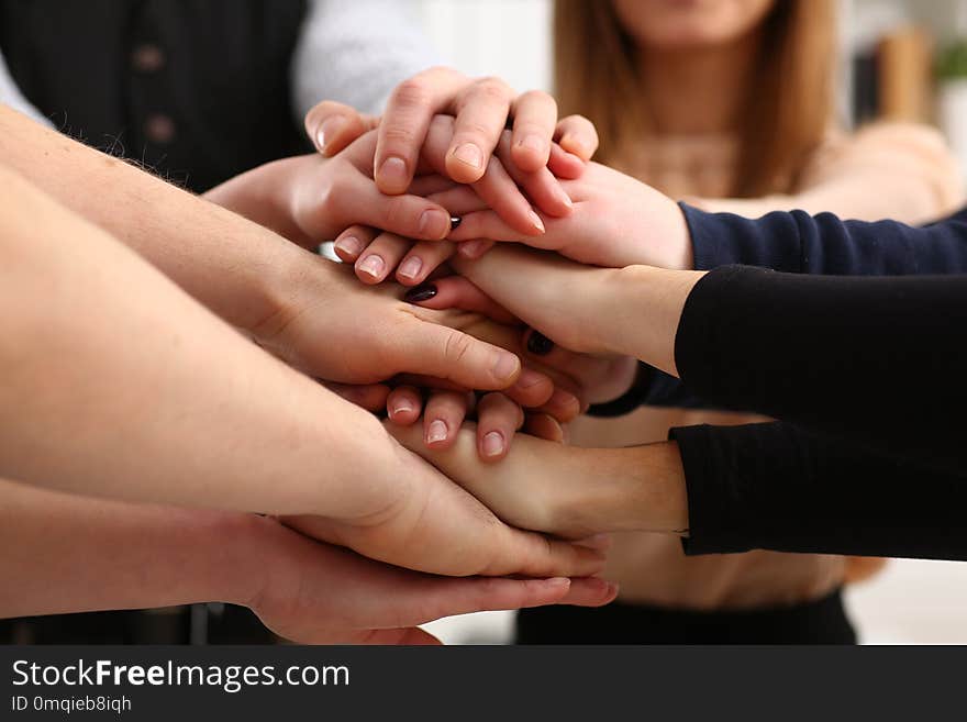 Group of people in suits crossed hands in pile for win closeup. White collar leadership high five cooperation initiative achievement corporate life style friendship deal heap stack concept