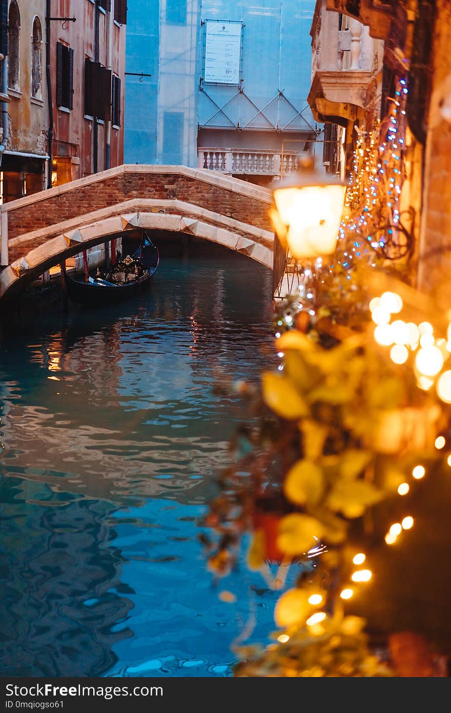 Venice canal late at night with street light illuminating bridge and houses