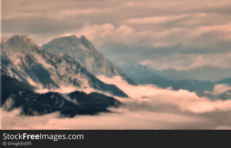 High mountain peaks rising from the fog in the valley, view to valley,high altitude scenic mountain landscape, steep rocks. Relaxing nature, bad weather,clouds, mist.Alps,Austria .