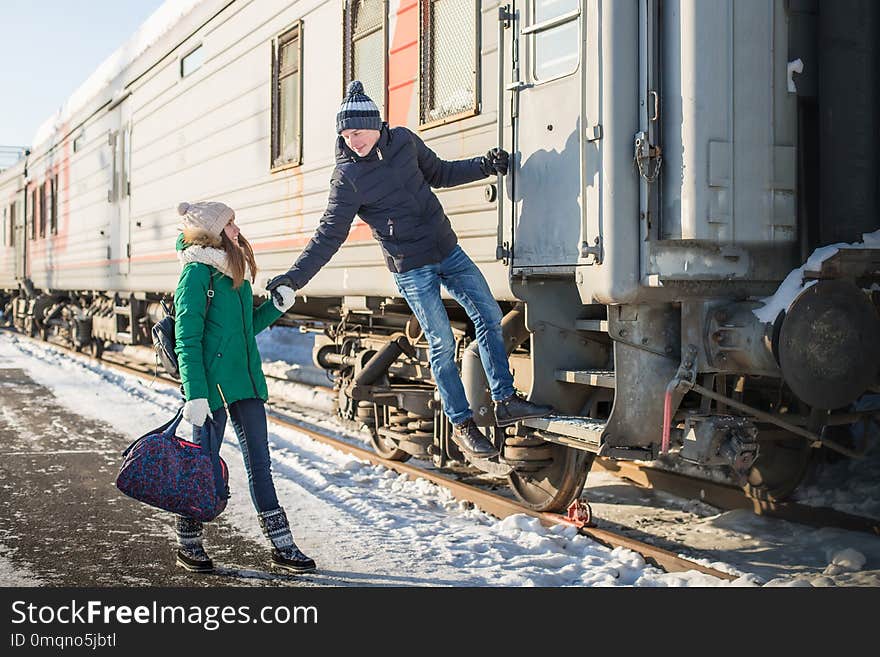 Couple at railway station near train in a winter time