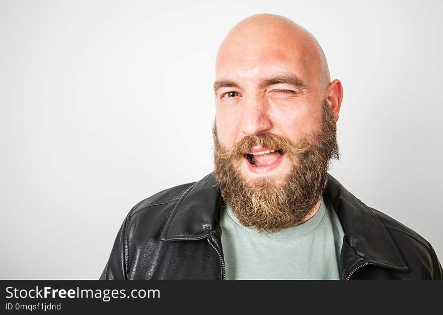 A smiling bearded man that winks