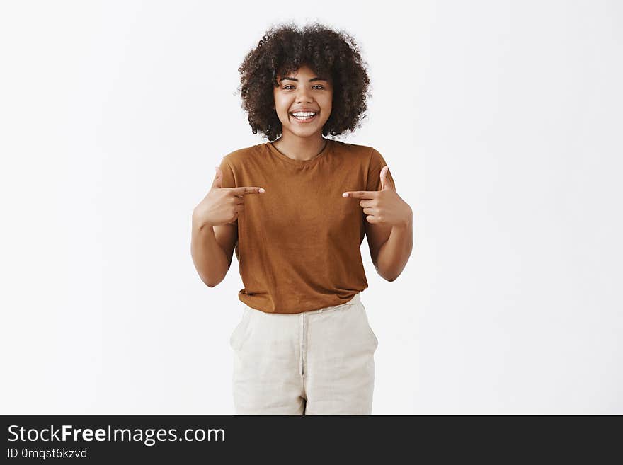 Studio shot of optimistic friendly african american girl with curly hair wanting being picked suggesting herself as