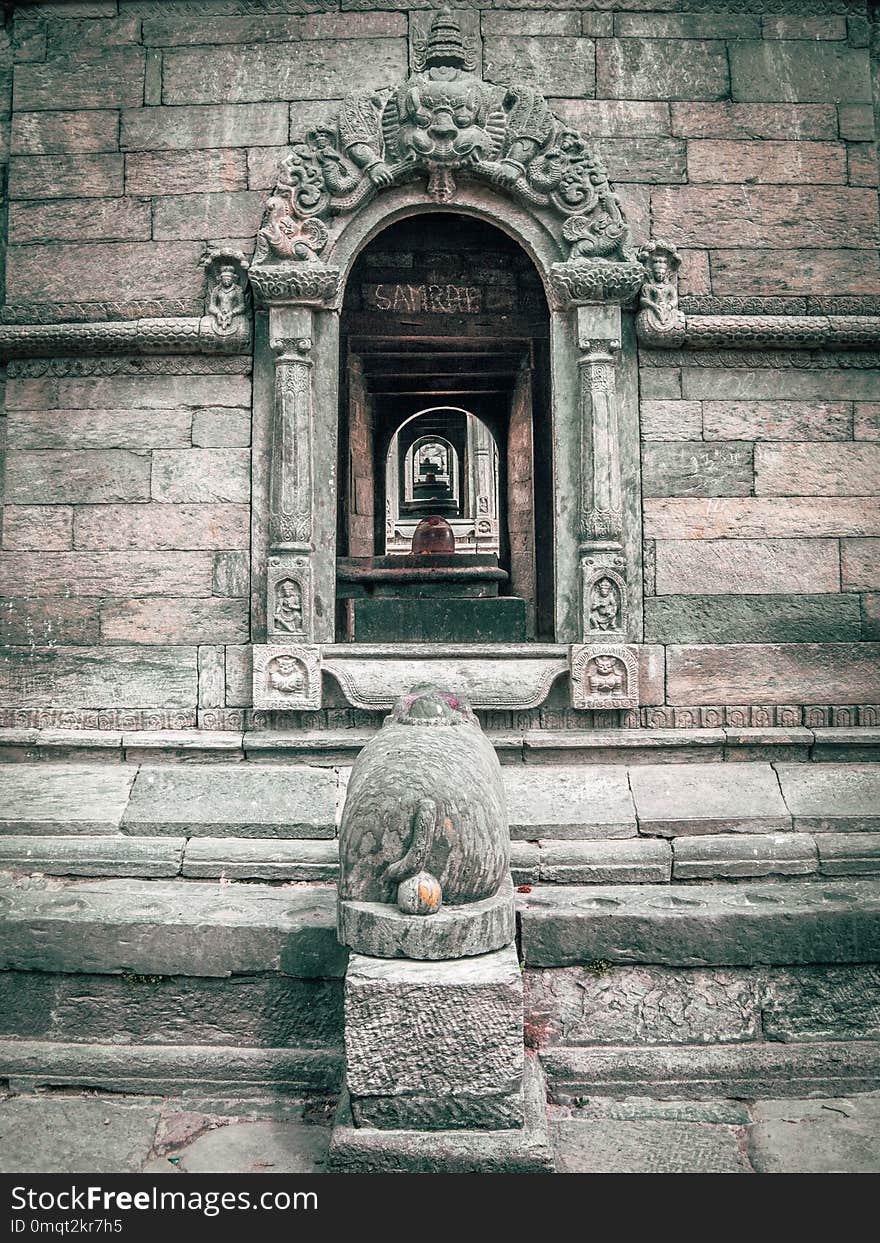 Close up of one window in old stone sacred building, inline with other windows in the background. Pashupatinath Temple in Kathmandu, Nepal.