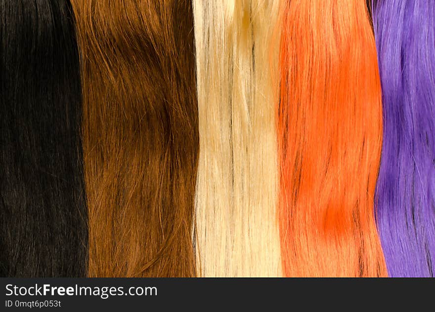 Closeup assorted multicolored hair extensions in blue, brown, blonde, orange, and purple hairs. Useful for salon, shampoo, styling advertisements. Closeup assorted multicolored hair extensions in blue, brown, blonde, orange, and purple hairs. Useful for salon, shampoo, styling advertisements.