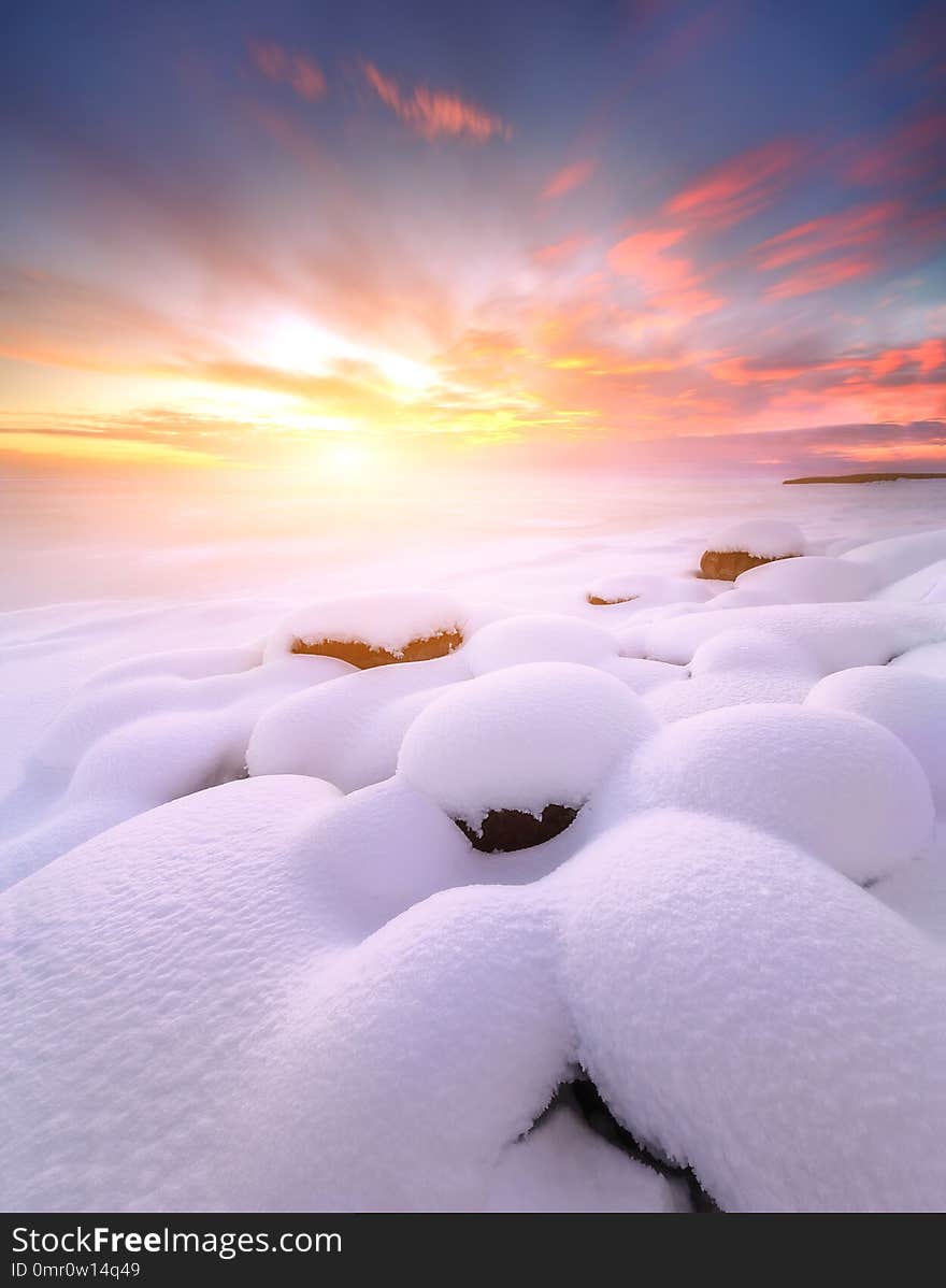 Winter sunset with snow-covered rocks. Composition of nature