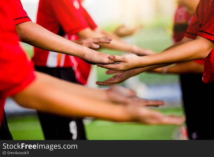 Young boy soccer players tap hands together for football training. Soccer players and goalkeeper traing speed hand together.