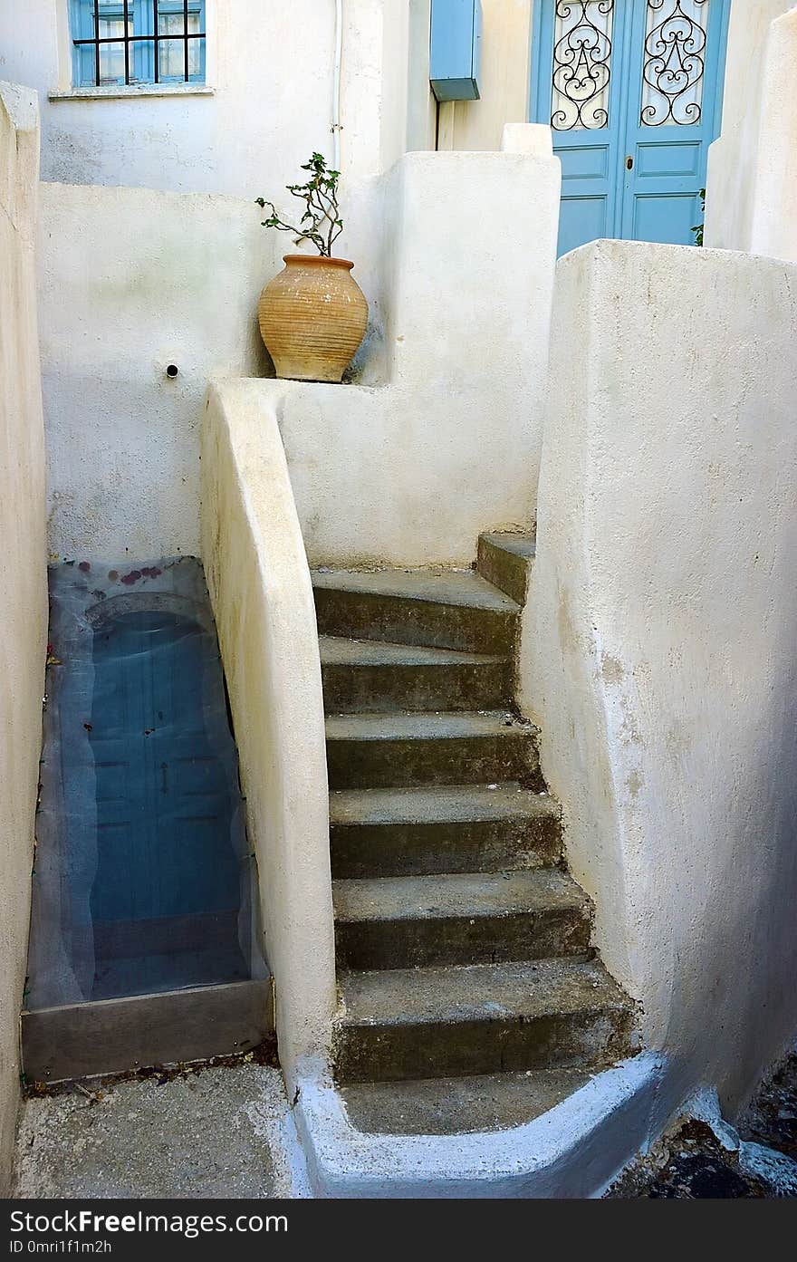 Crete architecture. White wall, blue doors and window, staircase and flower in clay pot. Greece. Crete architecture. White wall, blue doors and window, staircase and flower in clay pot. Greece