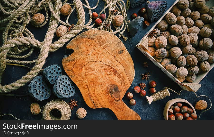 Wooden Board In The Center, Autumn Still Life On Dark Background, Nuts, Ropes And Flowers, Rustic Life