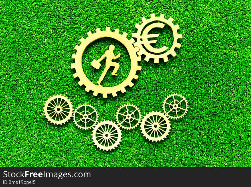 Gear, euro, man with a suitcase on the background of artificial green grass. business, finance, cash flow.