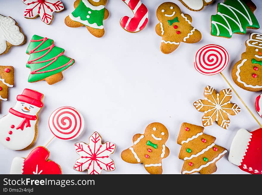 Various traditional colorful sugar glazed christmas gingerbread cookies, on white background top view copy space