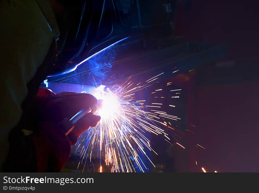 Grinding machine in production polishes the metal and sparks fly out of the abrasive wheel.