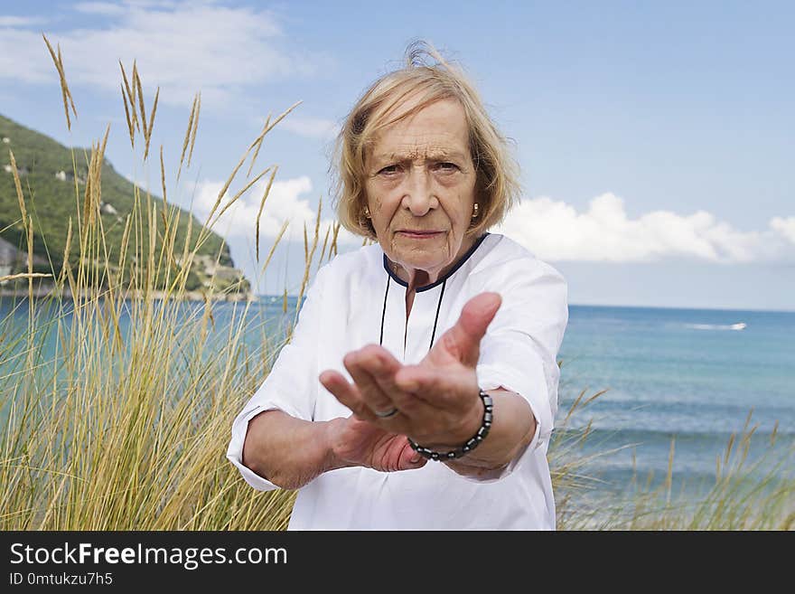 A senior woman practicing Tai Chi by the coast