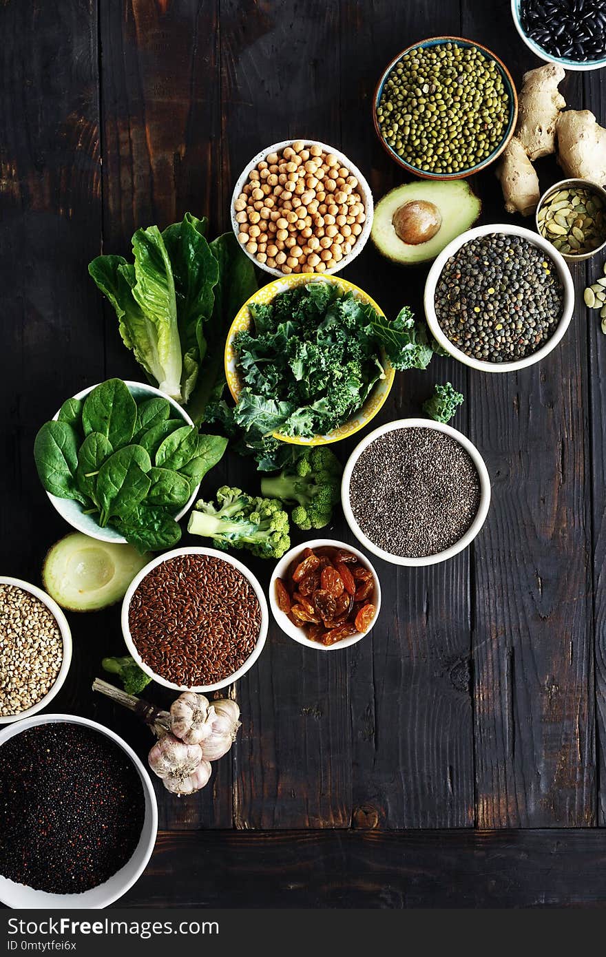 Set raw seeds, cereals, beans, superfoods and green vegetables on dark wooden background top view. vegetarian or diet food concept. Set raw seeds, cereals, beans, superfoods and green vegetables on dark wooden background top view. vegetarian or diet food concept