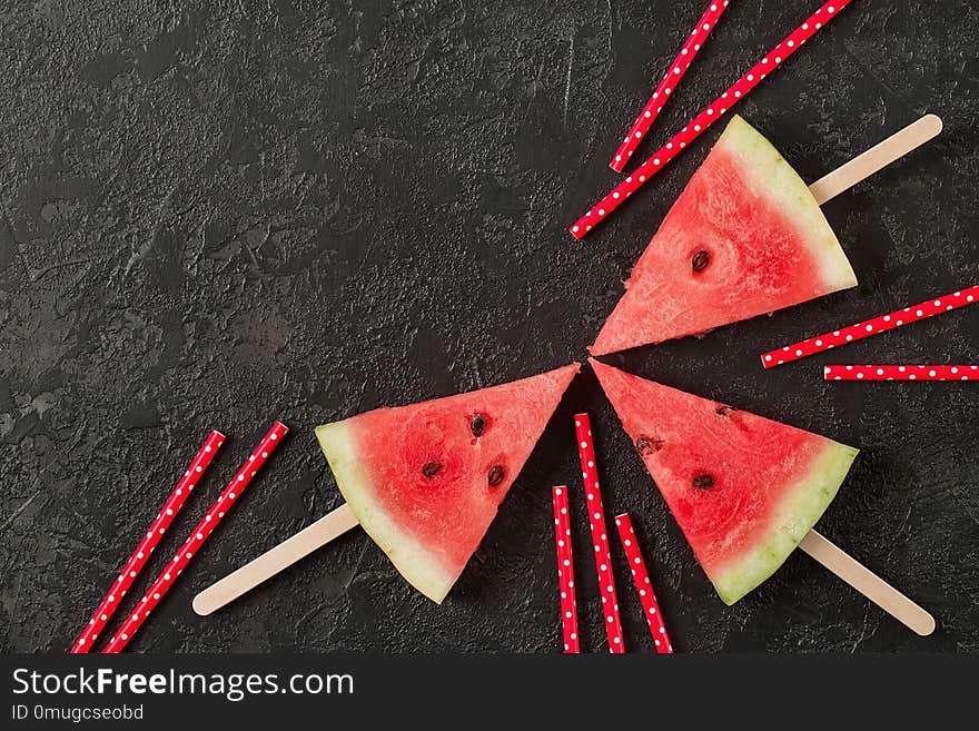 Fresh raw watermelon cut into pieces on dark stone background. Top view. Copy space. Fresh raw watermelon cut into pieces on dark stone background. Top view. Copy space.