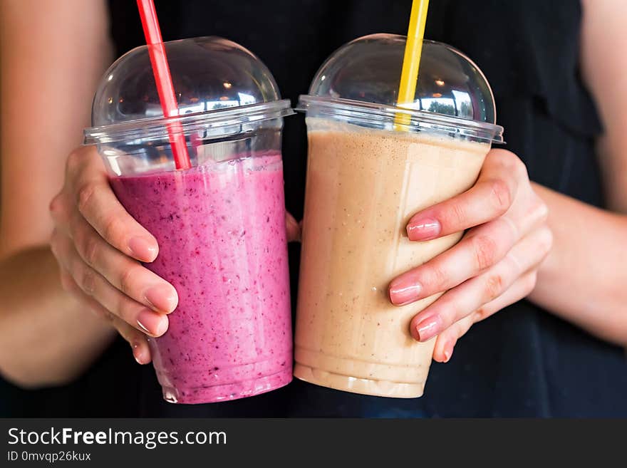 Hands hold two glasses with fresh smoothie