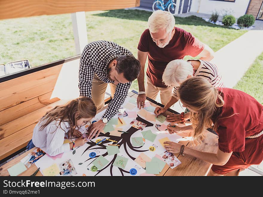 Pleasant interaction. Concentrated little girl bowing head while doing her family tree. Pleasant interaction. Concentrated little girl bowing head while doing her family tree