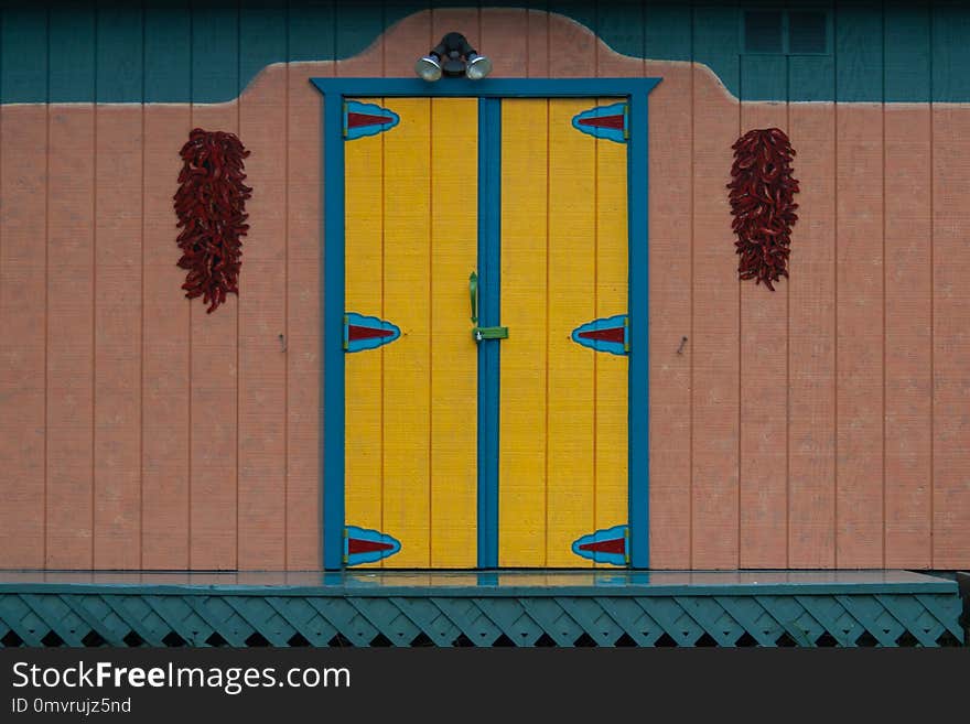 Colorful decorative Mexico door with some red peppers hanging on sides. Colorful decorative Mexico door with some red peppers hanging on sides.