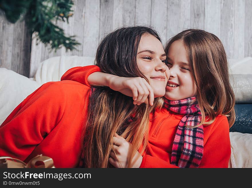 Two girls sisters have relax and fun in a room decorated for Christmas and the New year