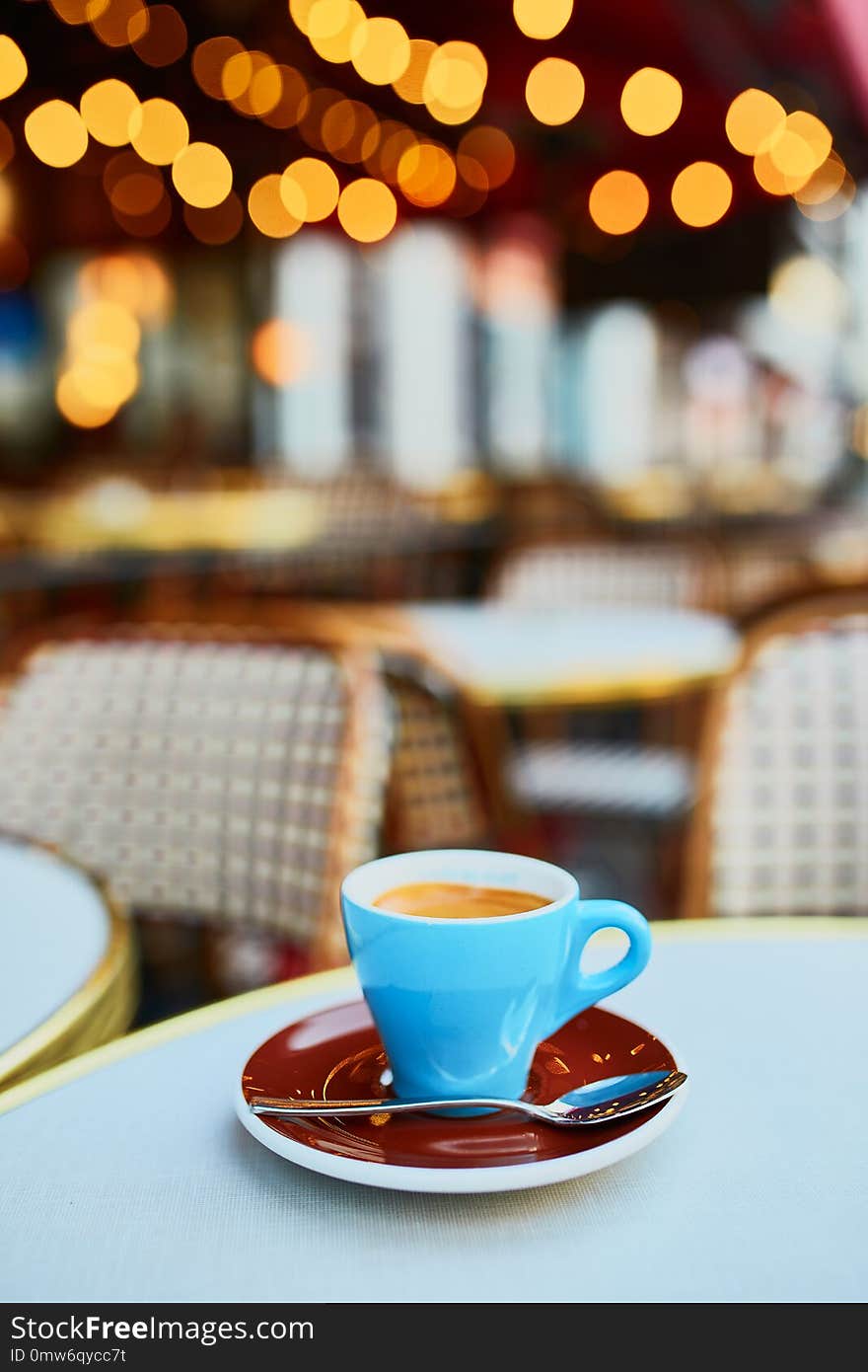 Cup of fresh hot espresso coffee on table of traditional Parisian outdoor cafe in Paris, France