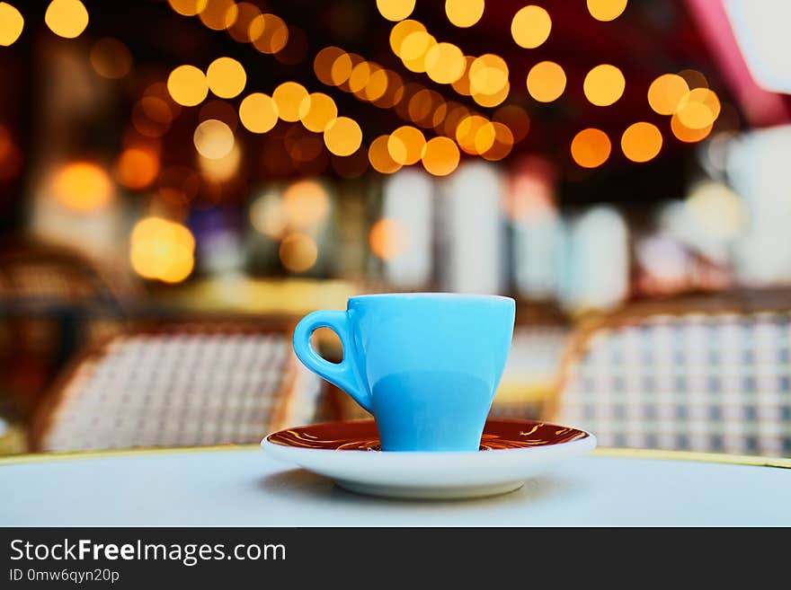 Cup of fresh hot espresso coffee on table of traditional Parisian outdoor cafe in Paris, France