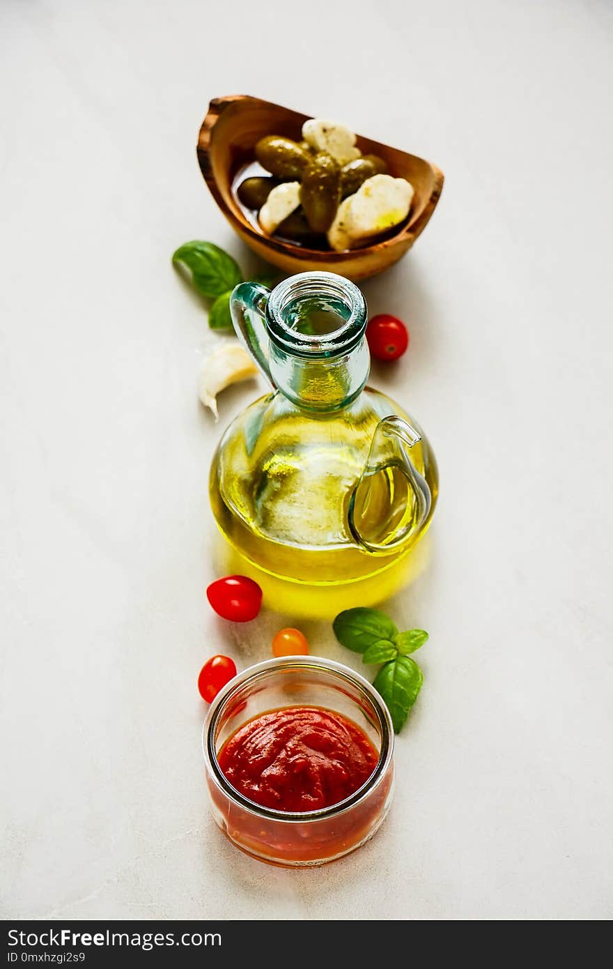 Italian cooking ingredients. Tomato sauce, olives, mozzarella, basil leaves and oil