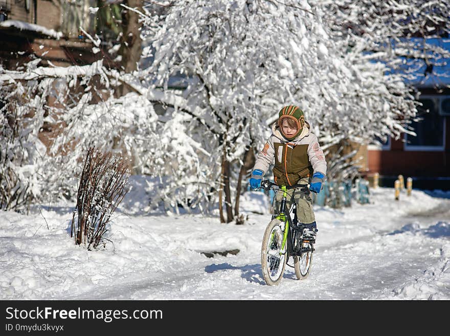 Happy young guy riding bike on fresh snow. Happy young guy riding bike on fresh snow