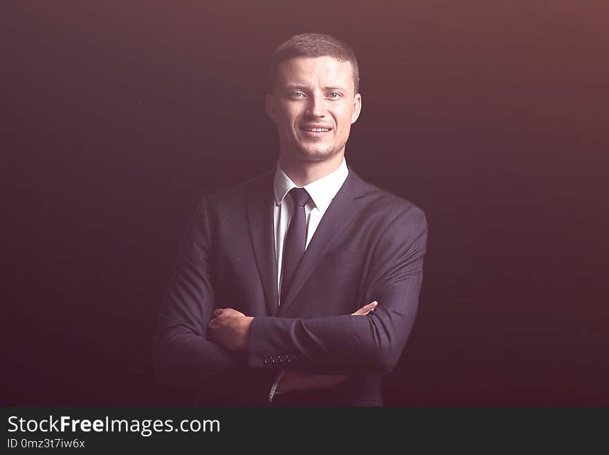 Confident smiling businessman isolated on a dark background. business concept. Confident smiling businessman isolated on a dark background. business concept