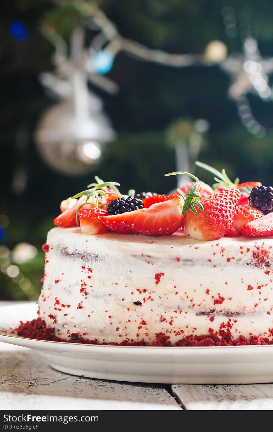 Homemade cake Red Velvet decorated with cream and berries over christmas background