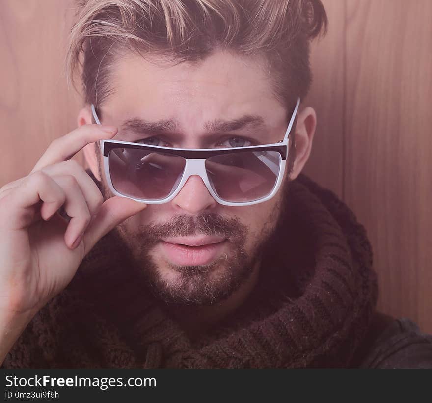 Confident man sitting on the floor on a wooden background