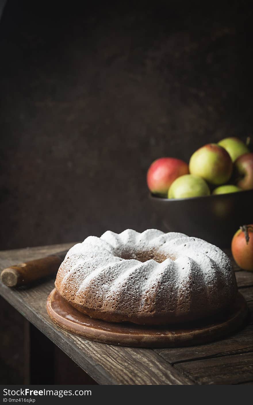 Rustic Style Apple Bundt Cake Sprinkled with Icing Sugar on old wooden table